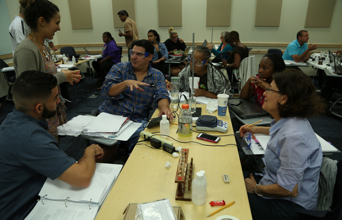 Melissa Maestu ’06 former institute participant was a facilitator at this year’s physical sciences institute. Here, she coaches a group of teachers who are also FIU alumni through an experiment.