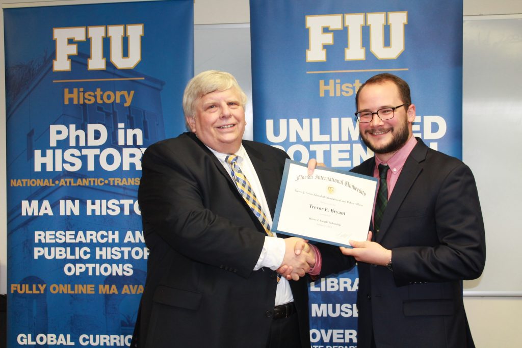 History alumnus Henry “Hank” Voegtle presents Trevor Bryant, the first recipient of his newly created fellowship, with the award.